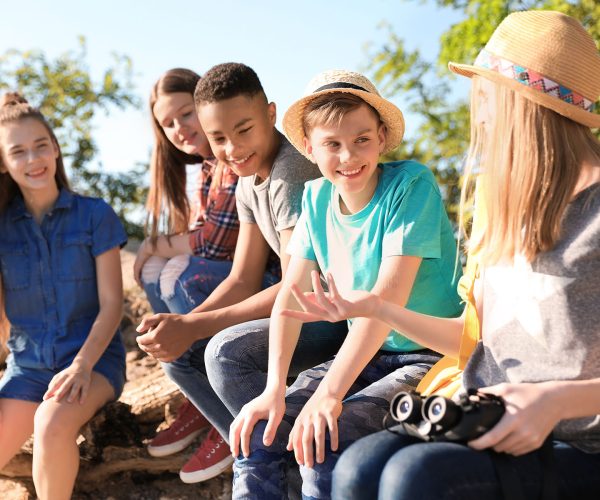 Group of children with binoculars outdoors. Summer camp