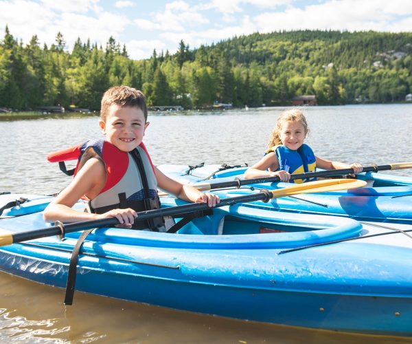 Summer vacation Portrait of cute boy and girl kayaking the on river