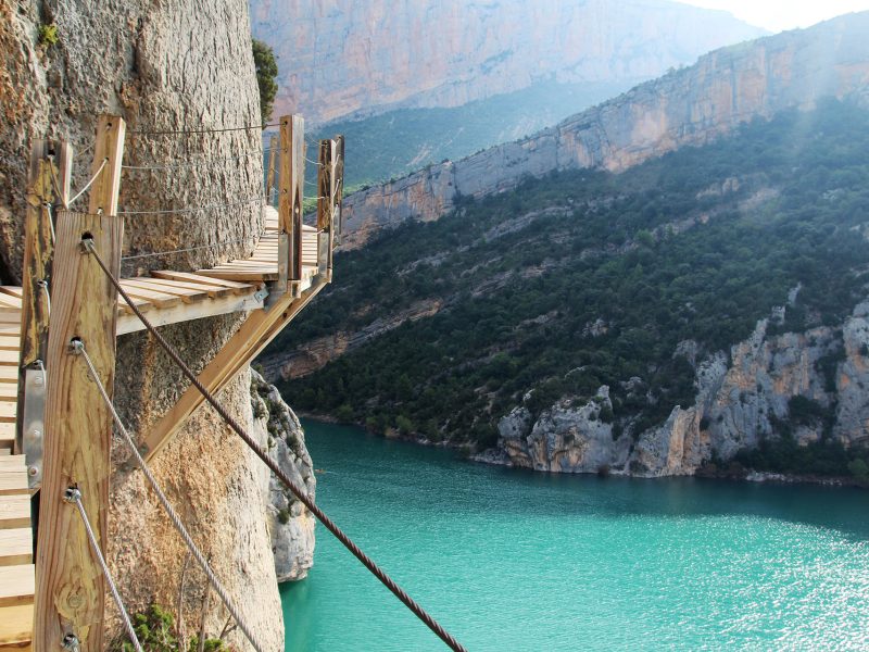 A wooden staircase at rock cliff as part of hiking path in Mont Rebei canyon, Spain